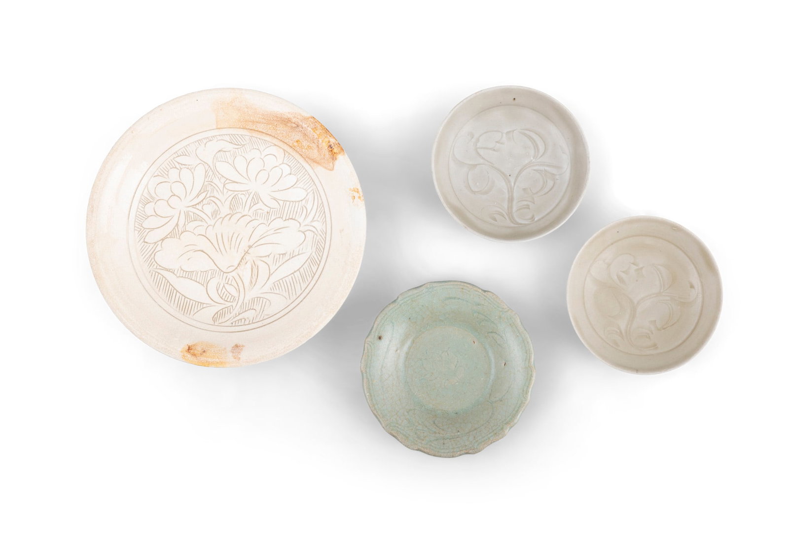 A GROUP OF FOUR CARVED 'FLORAL' CERAMIC BOWLS 宋-元 磁州及青: A GROUP OF FOUR CARVED 'FLORAL' CERAMIC BOWLS 宋-元 磁州及青釉刻花盌一组四件 China, Song-Yuan D.17.5-10cm Provenance