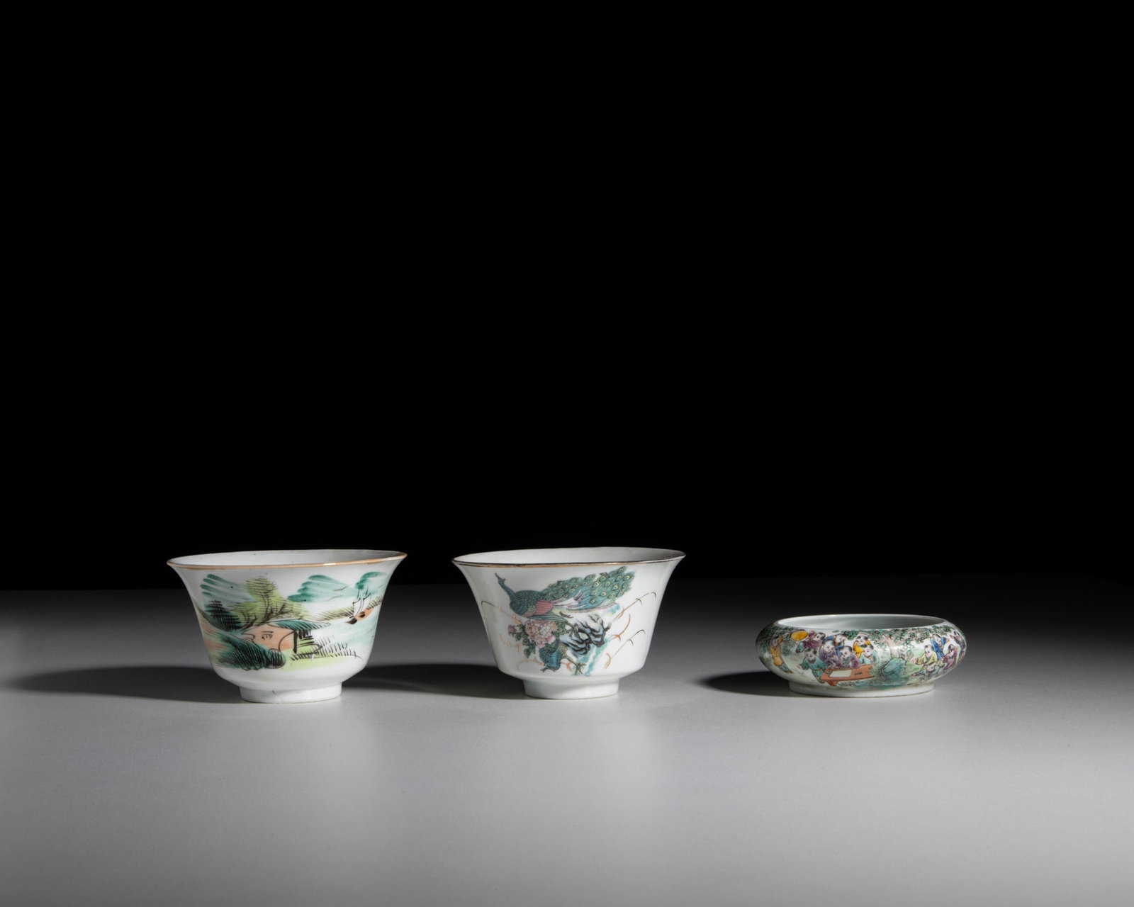 A GROUP OF THREE FAMILLE ROSE PORCELAINS 20世纪 粉彩茶碗两: A GROUP OF THREE FAMILLE ROSE PORCELAINS 20世纪 粉彩茶碗两件及百子图水盂 China, 20th century including two teacups a
