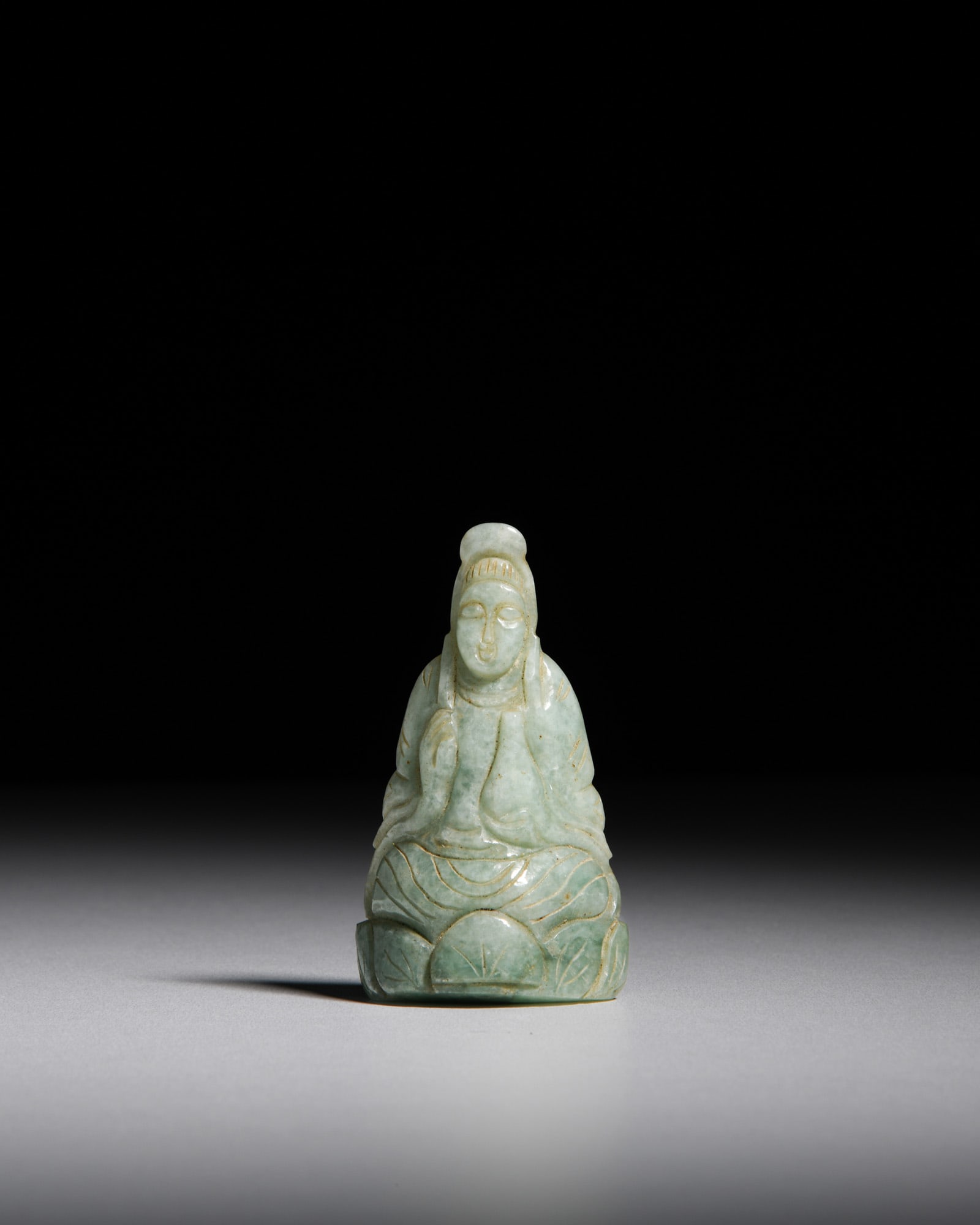 A JADEITE CARVED SITTING GUANYIN 晚清 翡翠雕观音 China,: A JADEITE CARVED SITTING GUANYIN 晚清 翡翠雕观音 China, late Qing dynasty H.8.2cm ***PLEASE NOTE: THIS LOT IS NOT ON VIEW IN IRELAND. POST-SALE COLLECTION IS 