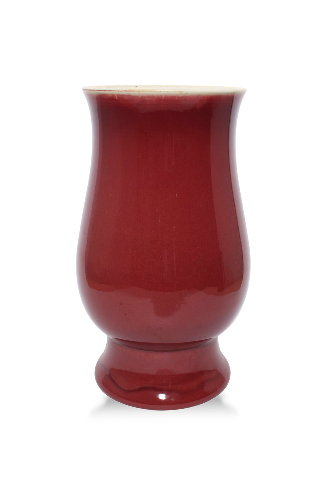 A CHINESE SANG DE BOEUF PORCELAIN VASE, 18th century, of unusual baluster shape, covered in deep red: A CHINESE SANG DE BOEUF PORCELAIN VASE, 18th century, of unusual baluster shape, covered in deep red glaze thinning towards a pale rim, the base drilled. 27.5cm high