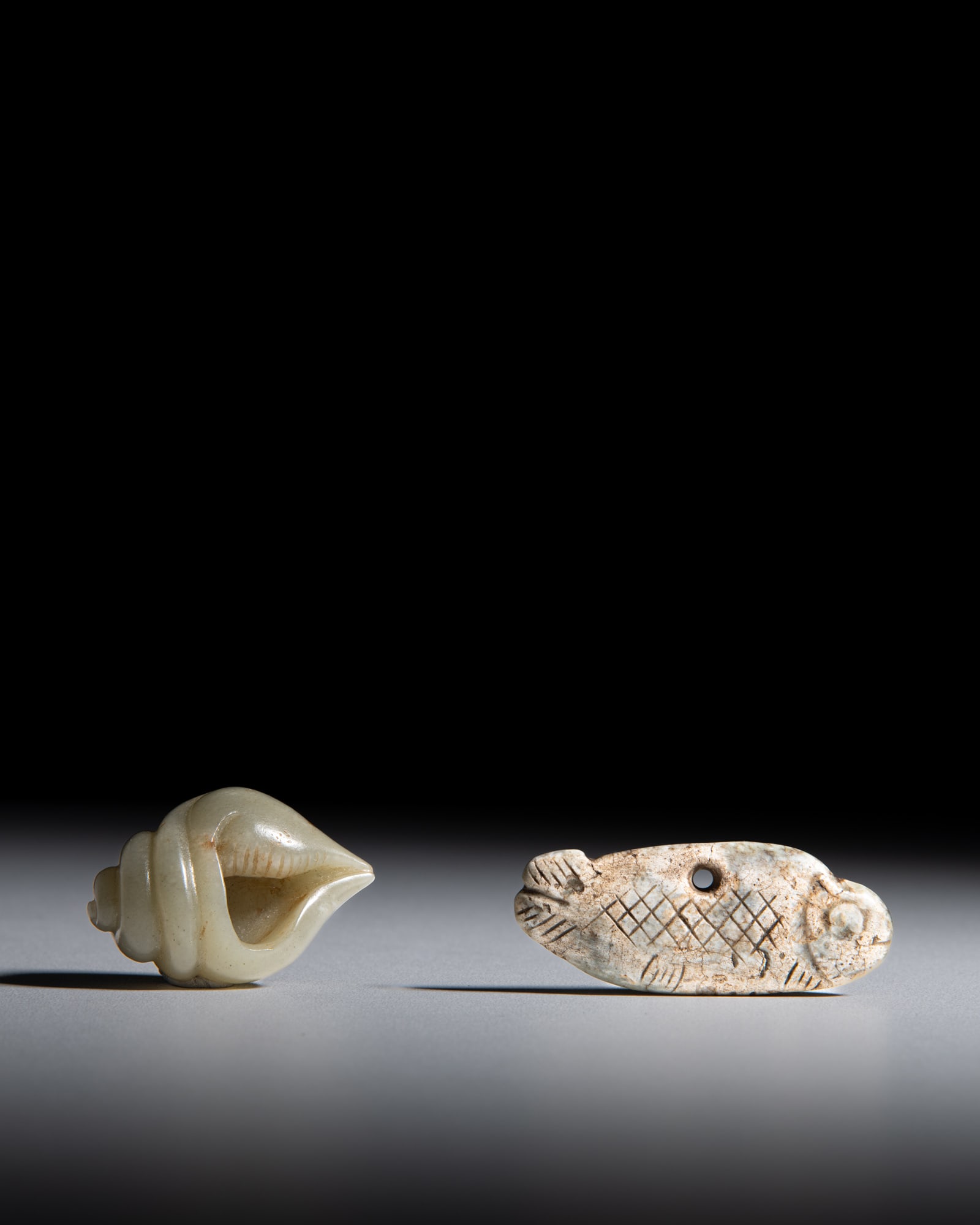 TWO PALE CELADON JADE 'FISH' AND 'CONCH' ORNAMENTS 清早期 玉螺、: TWO PALE CELADON JADE 'FISH' AND 'CONCH' ORNAMENTS 清早期 玉螺、玉鱼饰 China, early Qing dynasty L.6.2-4.7cm