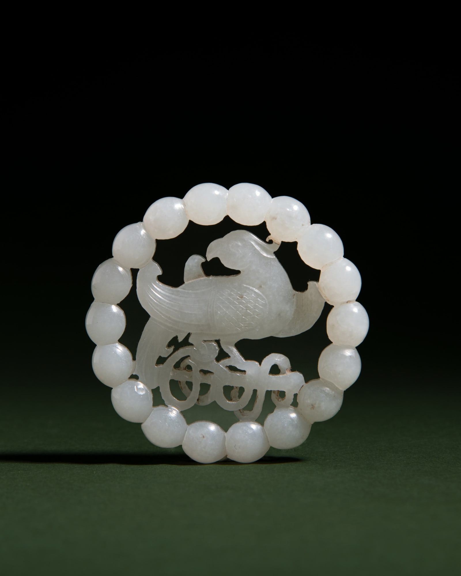 A PALE RETICULATED 'PARROT' JADE PENDANT 民国 白玉透雕鹦&: A PALE RETICULATED 'PARROT' JADE PENDANT 民国 白玉透雕鹦鹉玉佩 China, early 20th century D.5.5cm ***PLEASE NOTE: THIS LOT IS NOT ON VIEW IN 