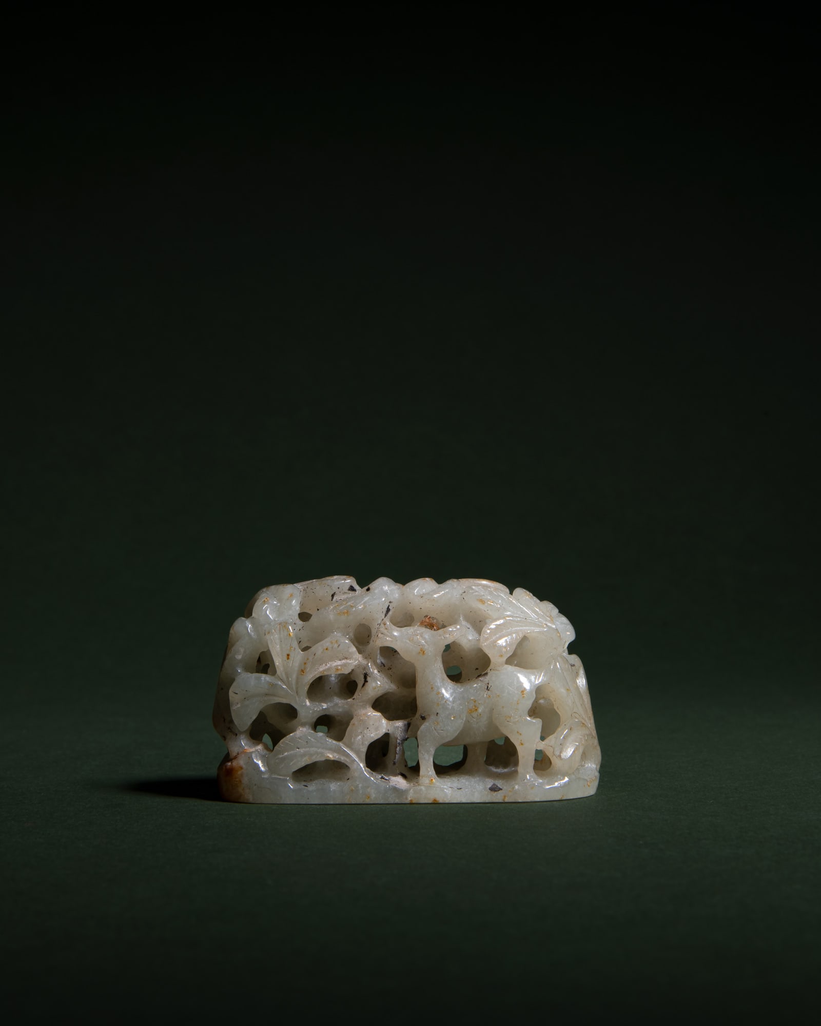 A CELADON JADE RETICULATED 'DEERS' HAT FINIAL 民国仿辽金 青: A CELADON JADE RETICULATED 'DEERS' HAT FINIAL 民国仿辽金 青玉透雕柞树群鹿图冠顶 China, Republic period L