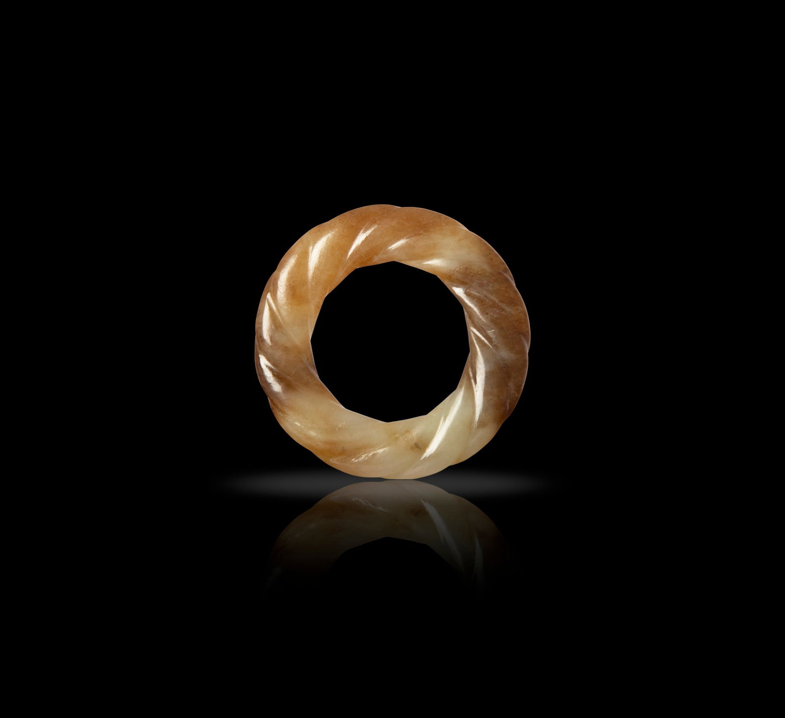 A SMALL PALE CELADON AND RUSSET JADE RING 明代 青白玉絞絲: A SMALL PALE CELADON AND RUSSET JADE RING 明代 青白玉絞絲紋環 China, Ming dynasty. D: 4.6cm