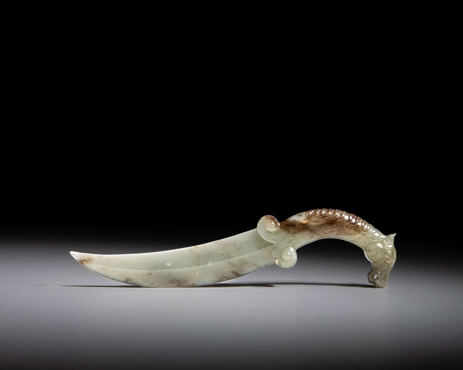 A MUGHAL STYLE HORSE HEAD HANDLED CELADON JADE KNIFE 痕都斯坦风: A MUGHAL STYLE HORSE HEAD HANDLED CELADON JADE KNIFE 痕都斯坦风格 青玉马头刀 L.21.3cm Provenance: Malaysian Chinese collection