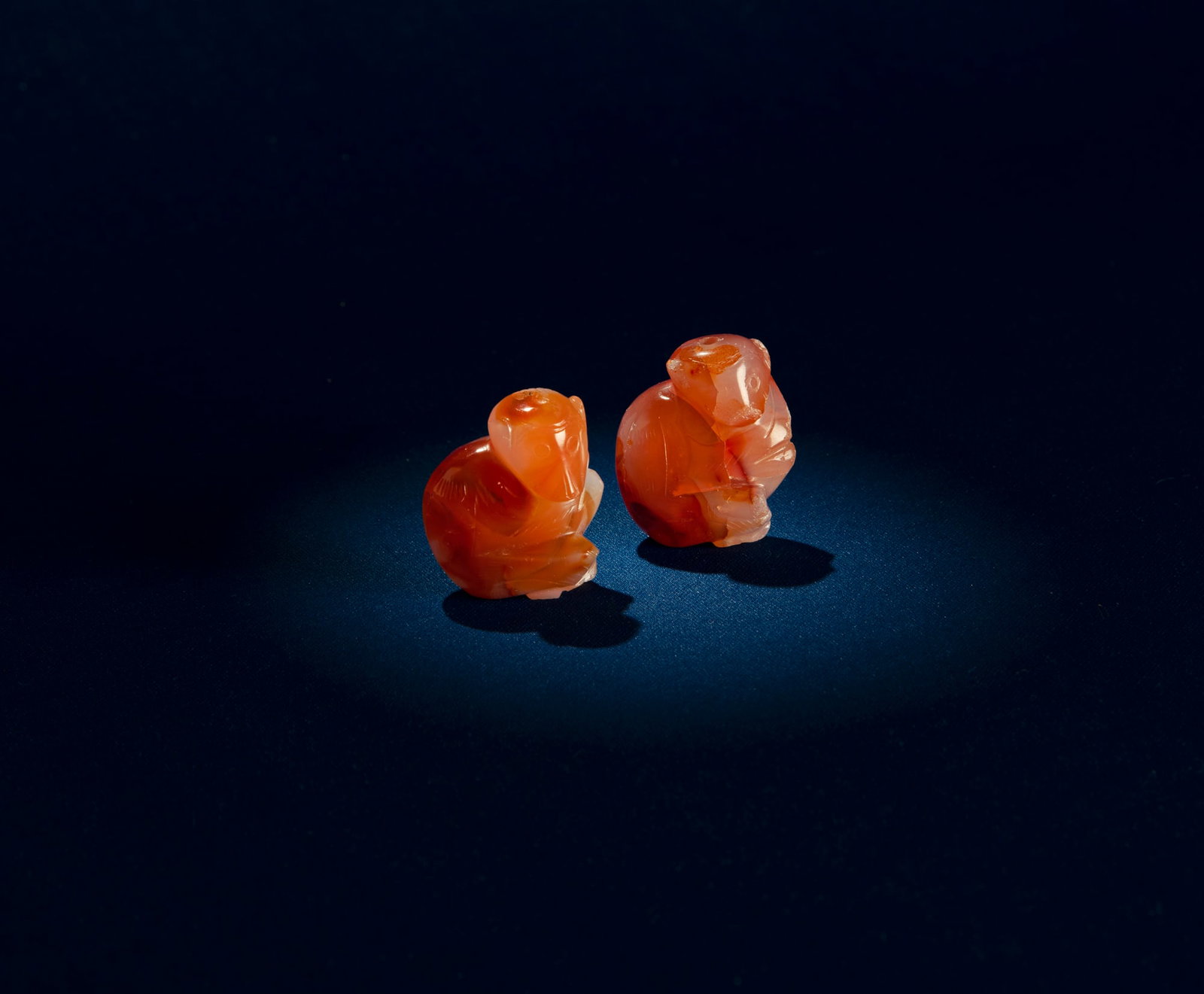 TWO MONKEY SHAPED CORNALINA PENDANTS China, Qing dynasty H.3.6cm: TWO MONKEY SHAPED CORNALINA PENDANTS China, Qing dynasty H.3.6cm
