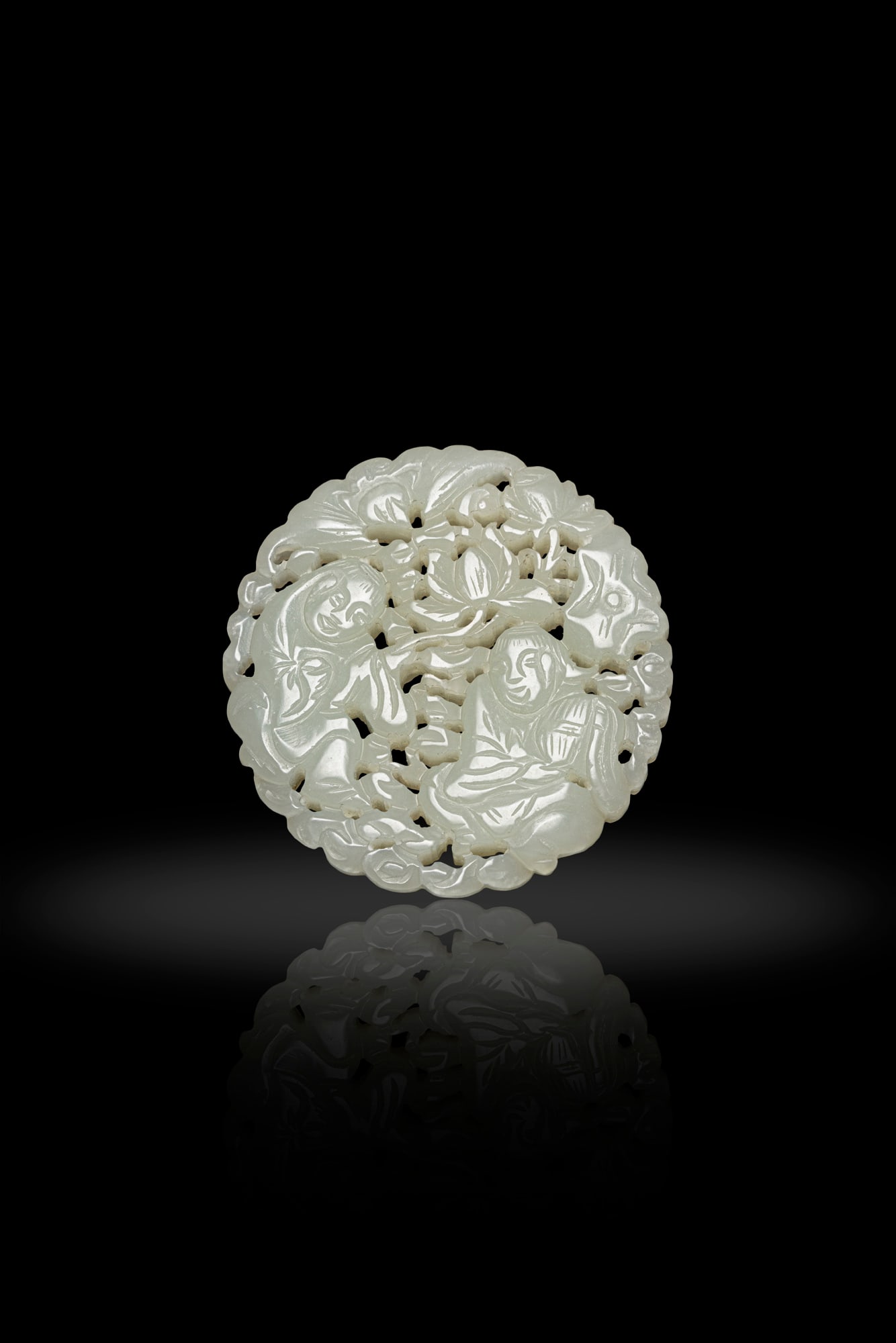 A RECULATED CELADON WHITE JADE 'HOHO BROTHERS AND LOTUS' PENDANT 19世紀 青白: A RECULATED CELADON WHITE JADE 'HOHO BROTHERS AND LOTUS' PENDANT 19世紀 青白玉透雕和合二仙玉佩 China, 19th century D.