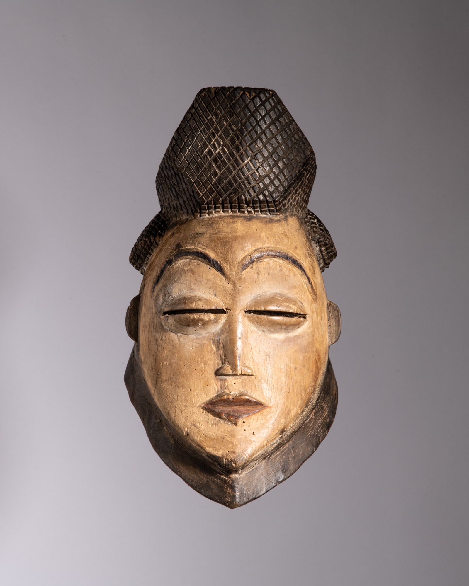 A PUNU WHITE CEREMONIAL OKUYI MASK Gabon Wood, kaolin, and pigment This exceptionally elegant and (1 of 3)
