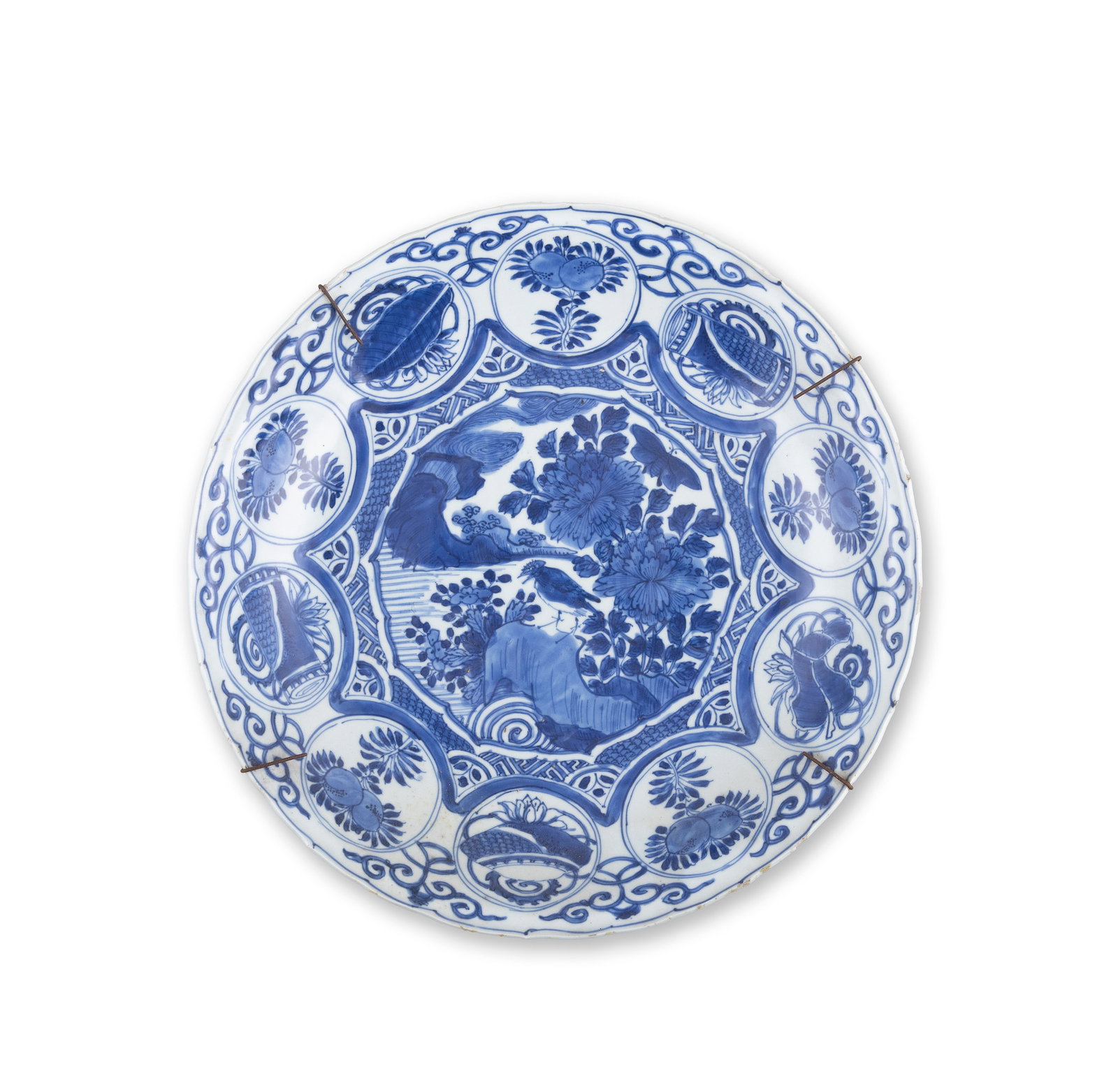 A BLUE AND WHITE CHARGER, Wanli Period (1573-1620) the central reserve decorated with a bird perche: A BLUE AND WHITE CHARGER, Wanli Period (1573-1620) the central reserve decorated with a bird perched on a rock, enclosed within a border of alternating circles containing gifts and fruits. 35cm diamet
