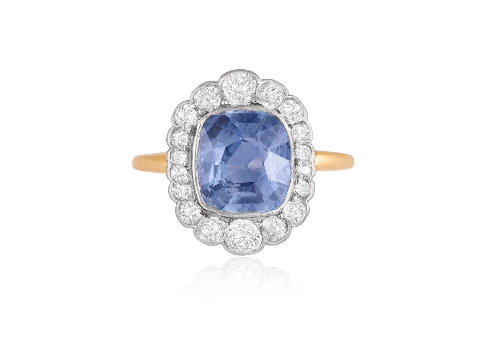 AN EARLY 20TH CENTURY SAPPHIRE AND DIAMOND RING Of cluster design, centring a cushion-shaped: AN EARLY 20TH CENTURY SAPPHIRE AND DIAMOND RING Of cluster design, centring a cushion-shaped sapphire within a graduated old brilliant-cut diamond surround, mounted in 18k gold and platinum, ring size