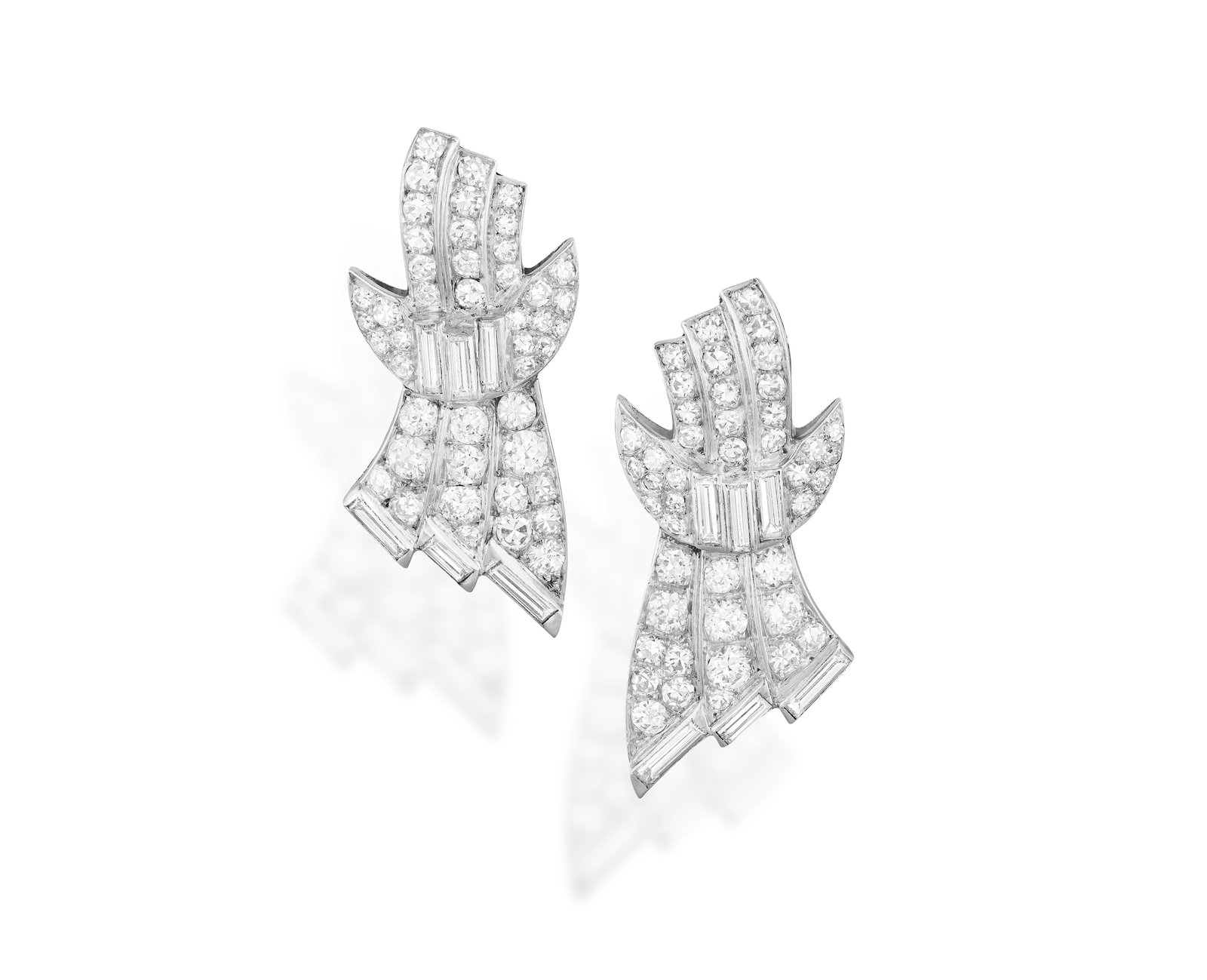 A PAIR OF ART DECO DIAMOND EARRINGS Each designed as a stylised bow, the tapering ribbon pavé: A PAIR OF ART DECO DIAMOND EARRINGS Each designed as a stylised bow, the tapering ribbon pavé-set with European and single-cut diamonds, highlighted with baguette-cut diamonds at the centre and termi