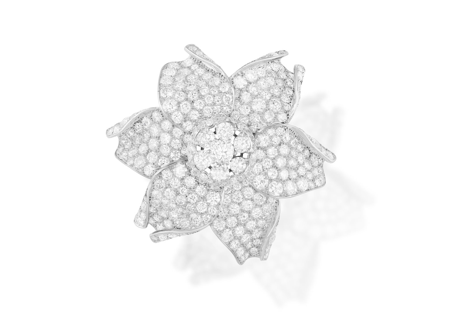 AN ELEGANT DIAMOND BROOCH, CIRCA 1955-60 Designed as a six-petal flowerhead, the curled and waved: AN ELEGANT DIAMOND BROOCH, CIRCA 1955-60 Designed as a six-petal flowerhead, the curled and waved petals pavé-set throughout with old and European-cut diamonds, centring a similarly-cut diamond clust