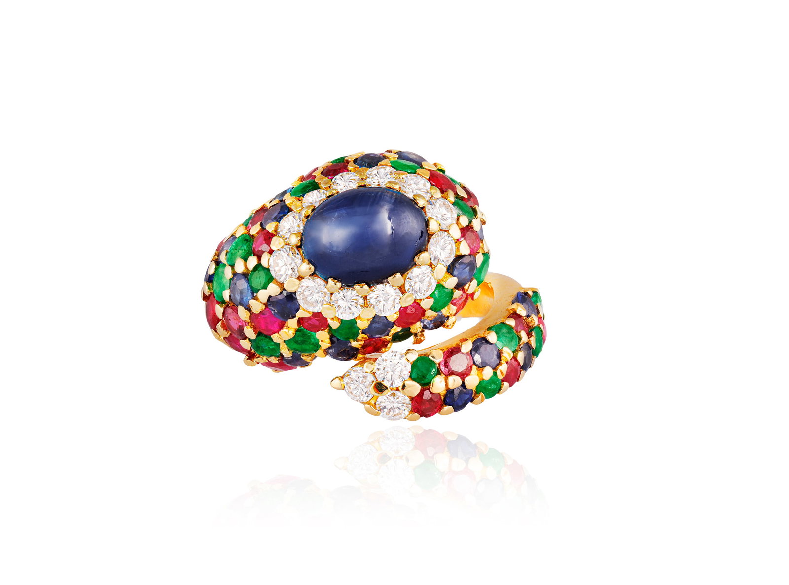 CHANTECLER: A GEM-SET DRESS RING Of crossover bombé design, the oval-shaped sapphire cabochon: CHANTECLER: A GEM-SET DRESS RING Of crossover bombé design, the oval-shaped sapphire cabochon within brilliant-cut diamond surround, set to the front with circular-cut sapphires, emeralds and rub