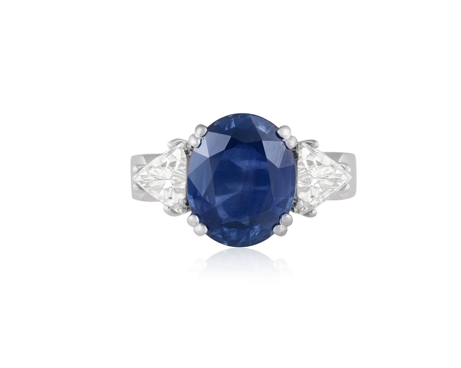 A SAPPHIRE AND DIAMOND DRESS RING The oval-shaped sapphire, within a four double-claw setting and (1 of 5)