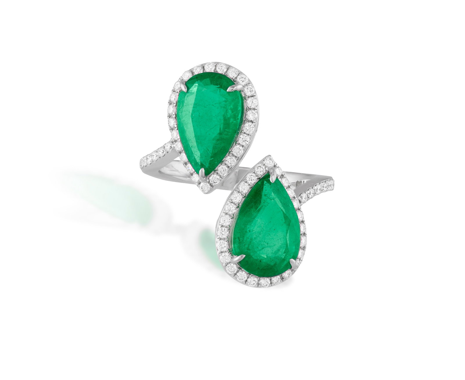AN EMERALD AND DIAMOND 'TOI ET MOI' RING Of crossover design, each pear-shaped emerald set within a: AN EMERALD AND DIAMOND 'TOI ET MOI' RING Of crossover design, each pear-shaped emerald set within a brilliant-cut diamond surround and shoulders, mounted in 18K gold, emeralds approximately 4.00cts to