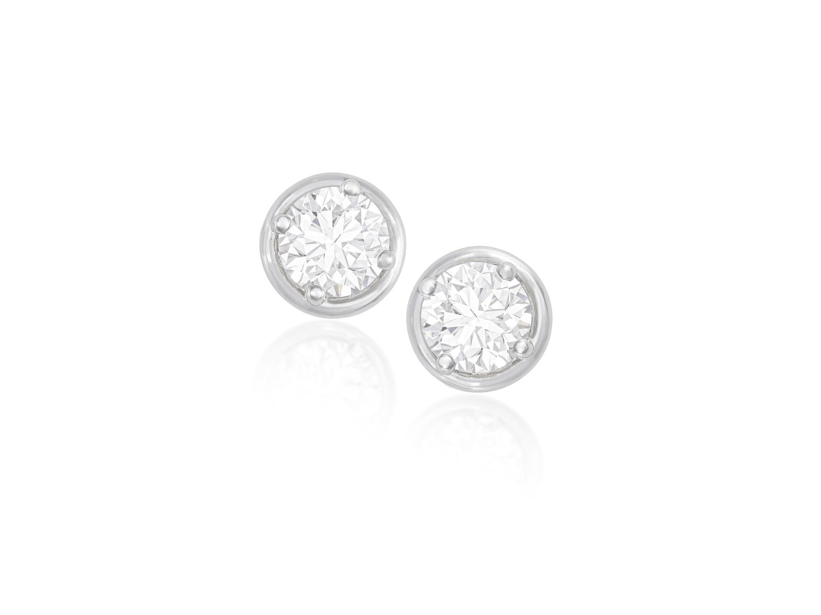 A PAIR OF DIAMOND EARSTUDS Each brilliant-cut diamond set with a four-claw setting within a: A PAIR OF DIAMOND EARSTUDS Each brilliant-cut diamond set with a four-claw setting within a polished circular surround, mounted in 18K gold, diamonds approximately 1.40cts total, Italian registry mark