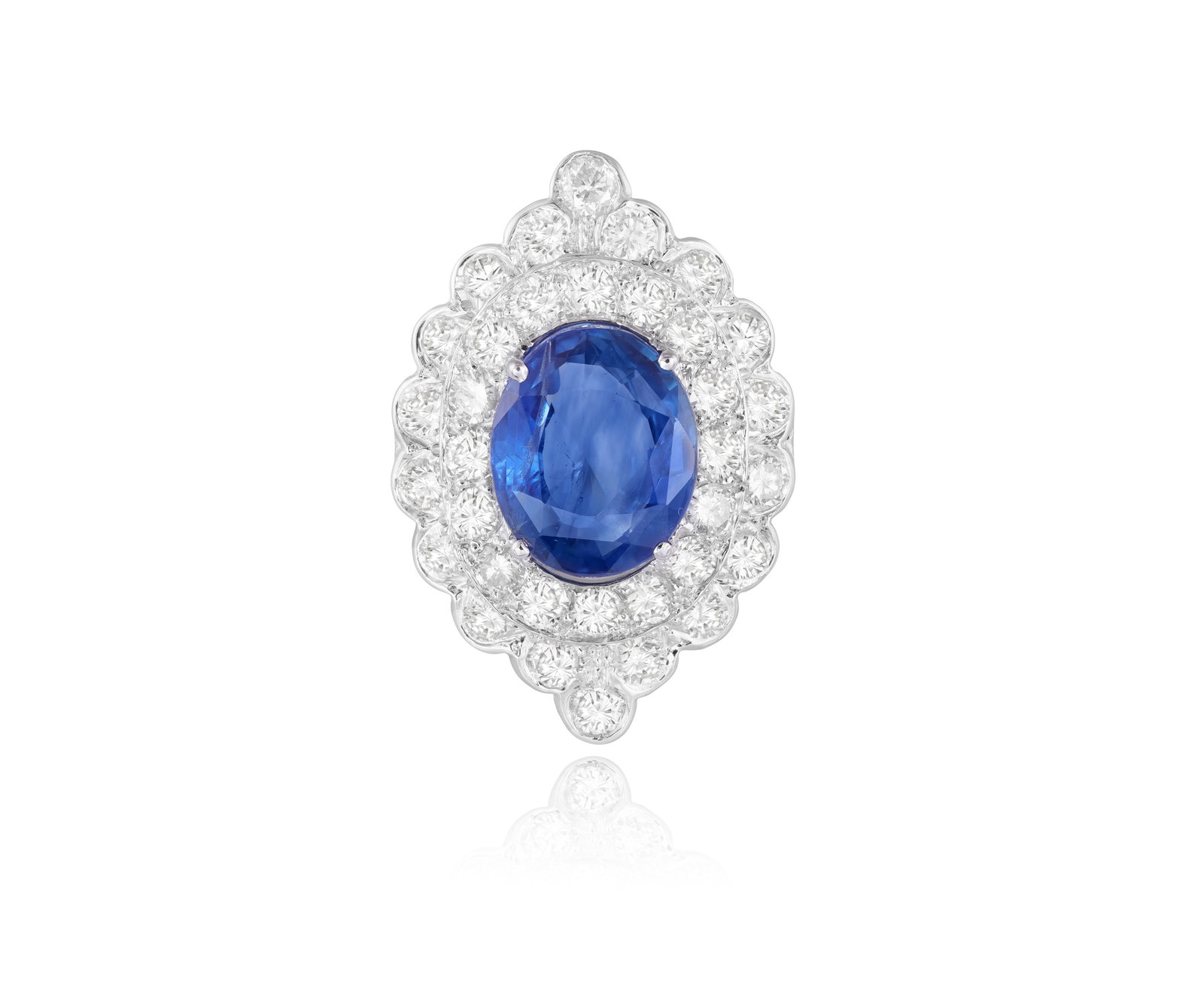 A SAPPHIRE AND DIAMOND CLUSTER RING Of navette design, centring an oval-shaped sapphire, to a: A SAPPHIRE AND DIAMOND CLUSTER RING Of navette design, centring an oval-shaped sapphire, to a double brilliant-cut diamond frame with scalloped detailing, mounted in 18K gold, diamonds approximately 2