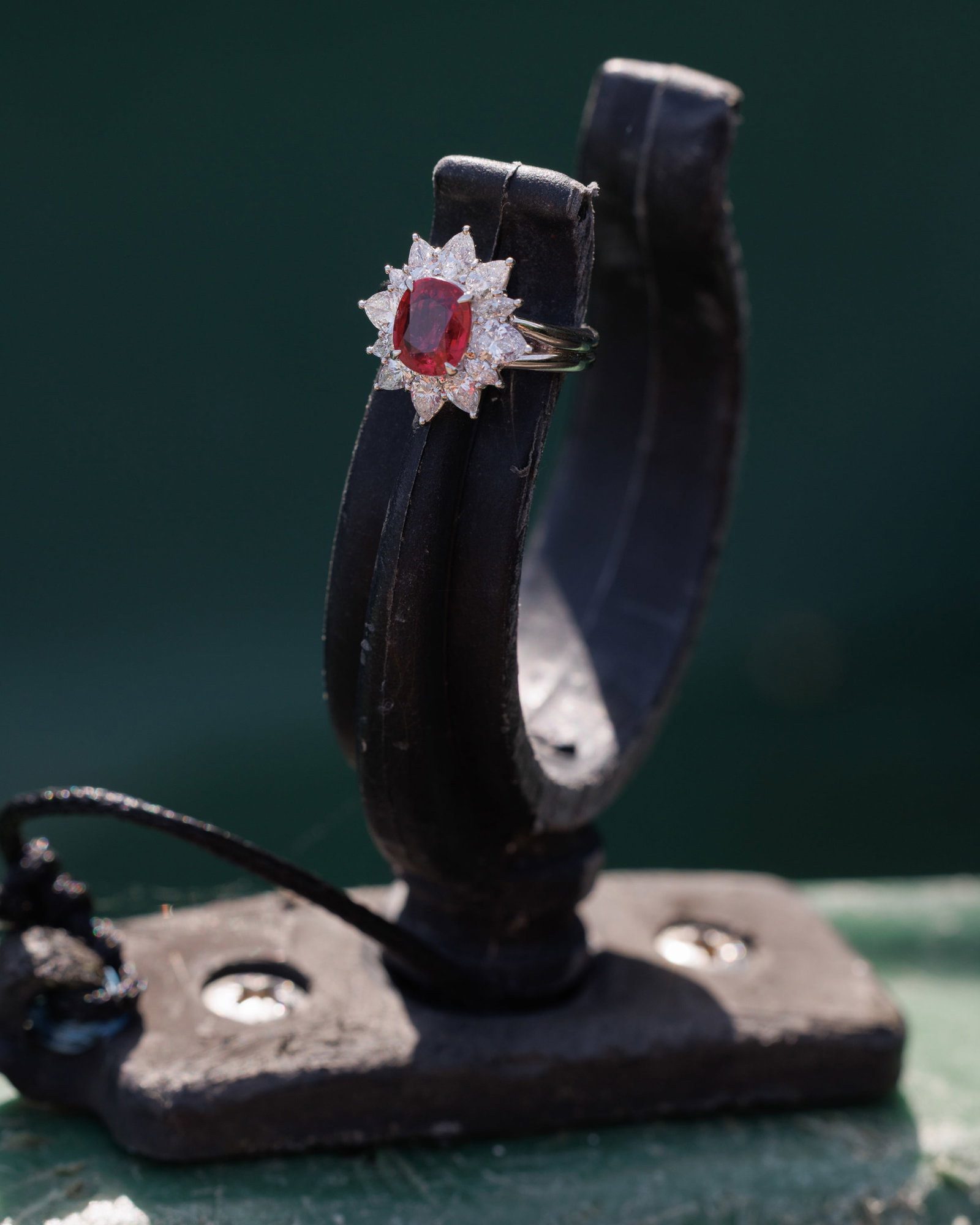 A RUBY AND DIAMOND CLUSTER RING Centring a cushion-shaped ruby weighing approximately 2.10cts, - 2