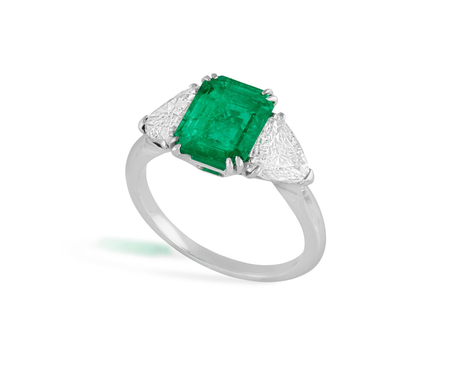A EMERALD AND DIAMOND DRESS RING The cut-cornered rectangular emerald, weighing approximately: A EMERALD AND DIAMOND DRESS RING The cut-cornered rectangular emerald, weighing approximately 1.60cts, within a four double-claw setting and between triangle-shaped diamond shoulders, mounted in 18K g