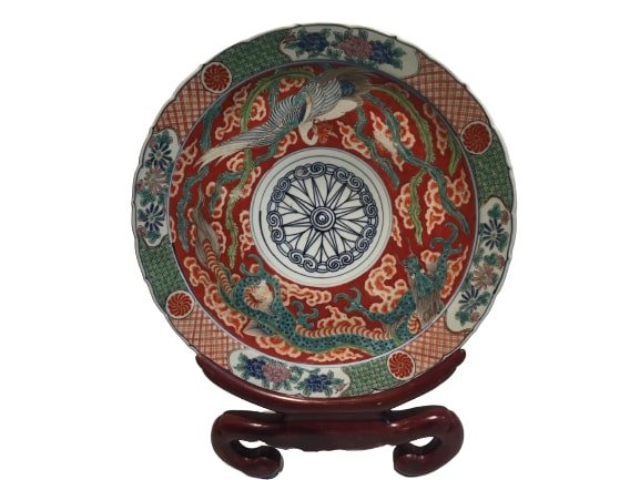 A large Japanese Imari porcelain charger: A large Japanese Imari porcelain plate with a wooden stand. Marked & inscribed in Japanese by the maker. The dimensions are 17" 1/2 inches in diameter.