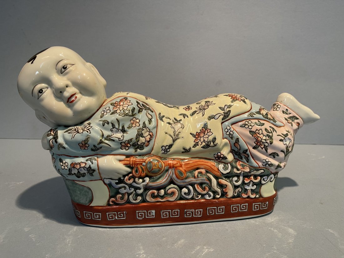A Chinese Porcelain Pillow: A Chinese Porcelain Pillow hand painted and glazed measuring 9 inches tall by 16 inches long. A unique smiling boy pillow.