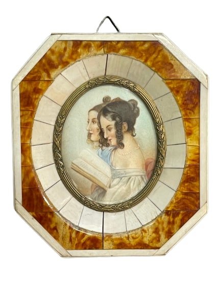 Antique Miniature oval painting: Antique Miniature oval painting of two young lady's reading a book framed in Bone and Tortoise Shell pentagon shaped frame. Sight measures 2 inches wide by 2 1/2 inches long and the frame measures 3 7