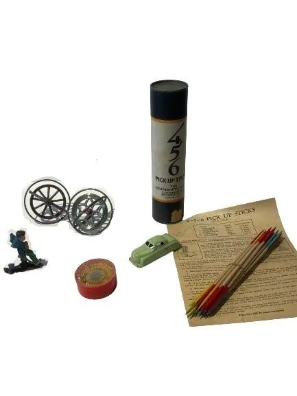 A group of mixed toys & game: A group of mixed toys & game , pick up sticks, a car, Spin a word & two Tops.