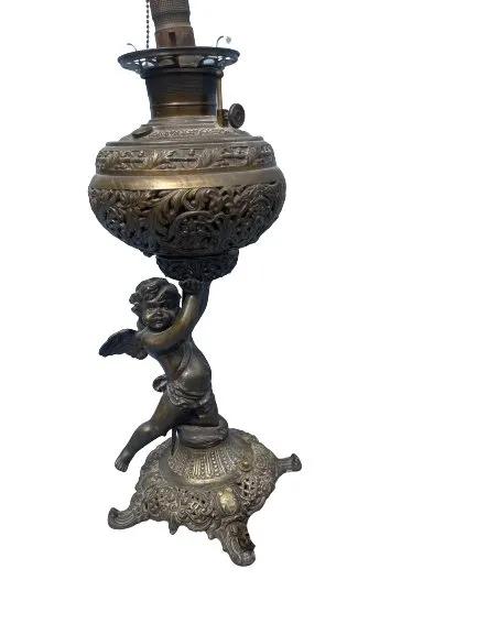 Antique Cherub Bronze Table Lamp: Antique Cherub Bronze Table Lamp. A kerosene lamp converted into an electrical lamp. Measuring 23 inches tall.