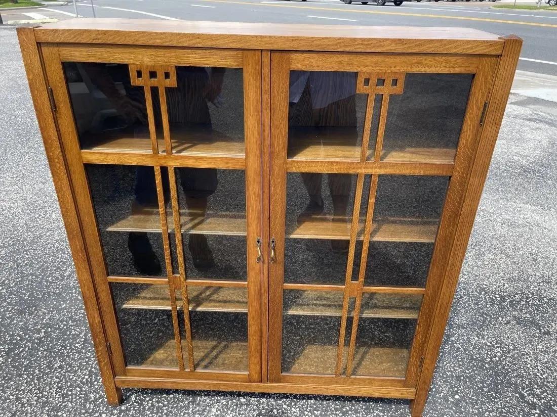 A stickley style Mission Oak and Glass paneled Bookcase: An american stickley style Mission Oak and Glass Bookcase. measurements : 13 x 47 x 53 inches tall with 2 glass paneled doors