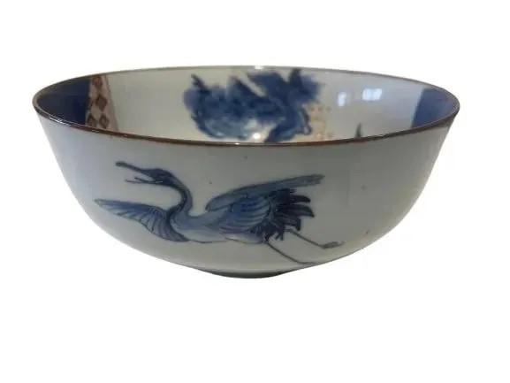 A decorative Japanese Porcelain bowl: A decorative Japanese Porcelain bowl measuring 9 1/2 inches in diameter by 4 1/2 inches tall. A unique Crane blue, red & white design.