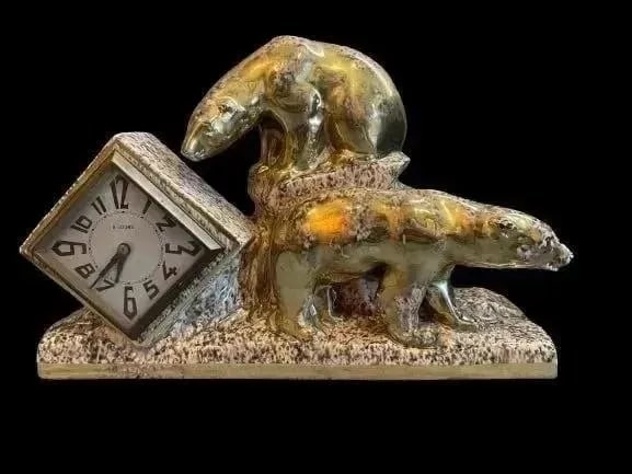8 day time & strike porcelain Polar Bears mantel clock: An 8 day time & strike porcelain Polar Bears mantel clock. Glazed gold & stone porcelain.