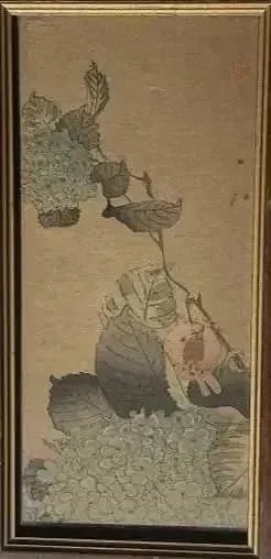A Japanese Woodblock print: A Japanese Woodblock print of a bird on a tree branch.Sight measures 3 1/8 inches wide by 7 inches long. Glass covered frame measures 4 1/4 by 8 inches long. red stamp lower left.