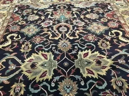 A handwoven Indian Heriz wool rug: A handwoven Indian Heriz wool Rug. Measuring 9 ft wide by 12 ft long.