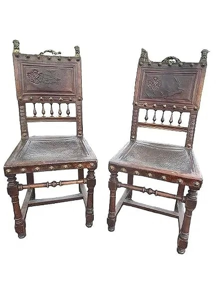 Pair of Antique Spanish chairs with embossed dragon emblems: Pair of Antique Spanish chairs with embossed dragon emblems. Bronze heads and dragon on the top backs. Highly decorative late 18th century chairs.