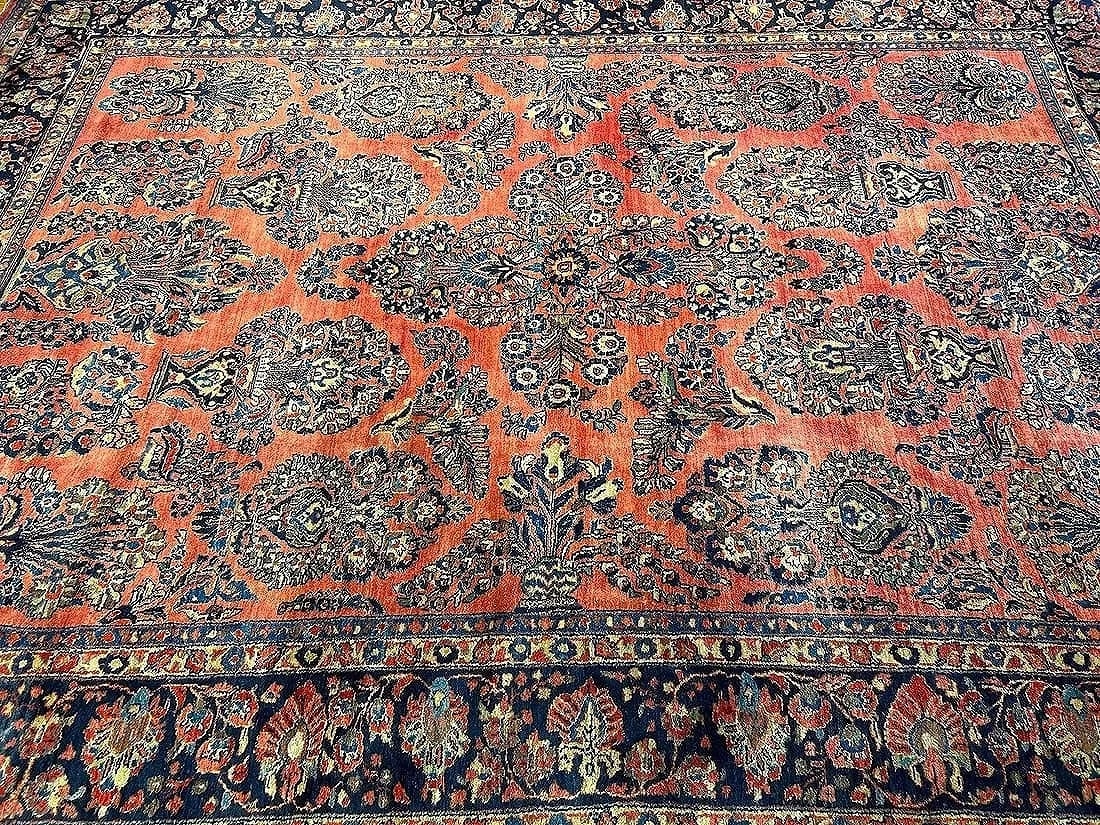 Antique Persian Sarouk room size rug: Antique Persian Sarouk room size rug measuring 8 feet 9 inches wide by 11 feet 8 inches long. A genuine Antique handwoven wool Persian floral Sarouk rug on a wine field with Navy blue borders.