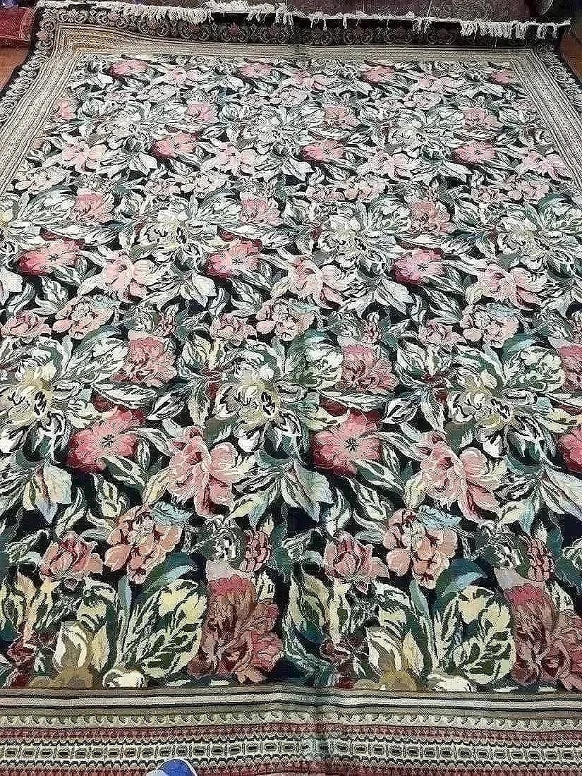 A handwoven Pakistan large size rug: A hand woven Pakistan floral design wool room size rug. An all over floral pattern with a rich color palette. Measurements: 10 feet 1 inch wide by 14 feet 1 inch long.
