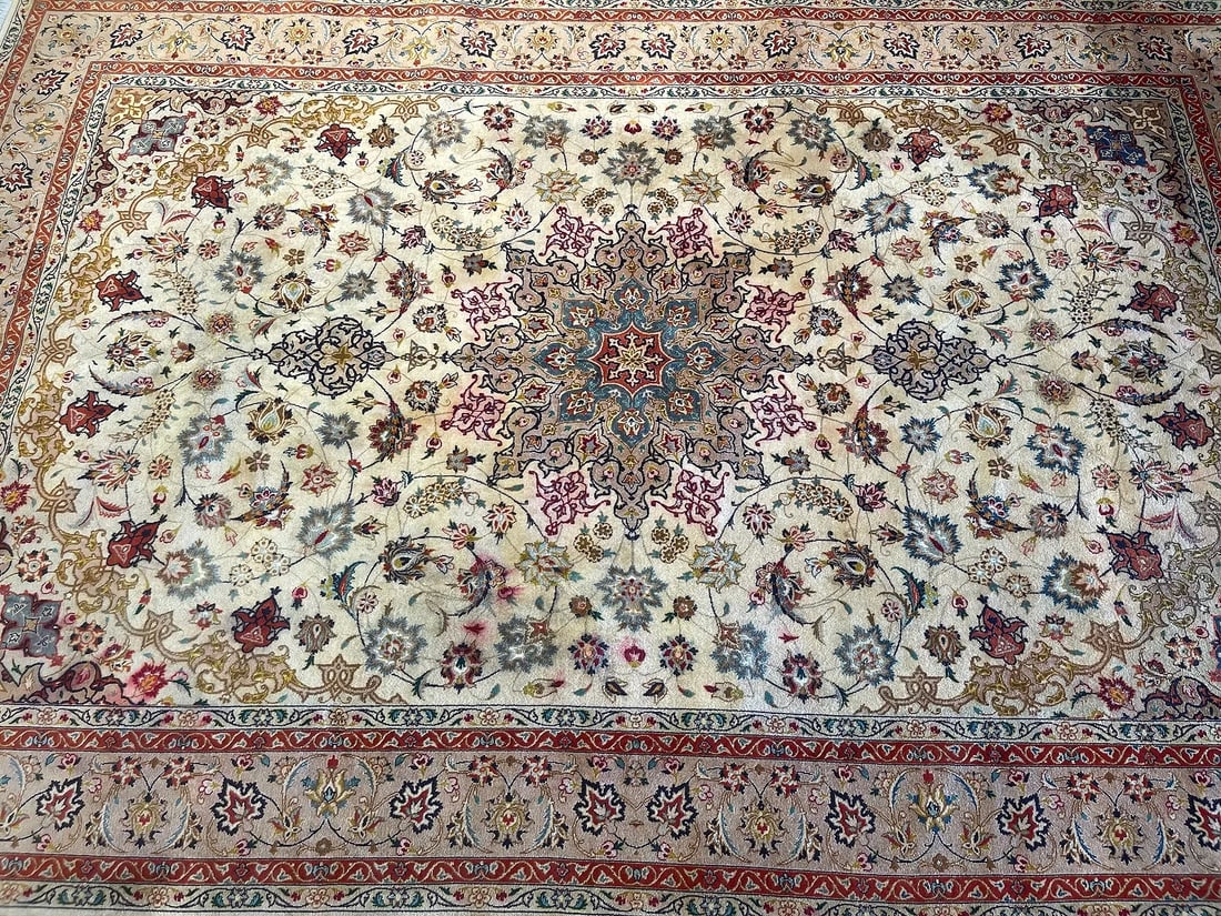 A Persian Tabriz rug: A Persian Tabriz rug measuring 6 feet 5 inches long by 9 feet 9 inches long. A Used finely woven Persian Tabriz rug made with wool & silk highlights with cotton tassels or fringes.SHIPPING: As courtes