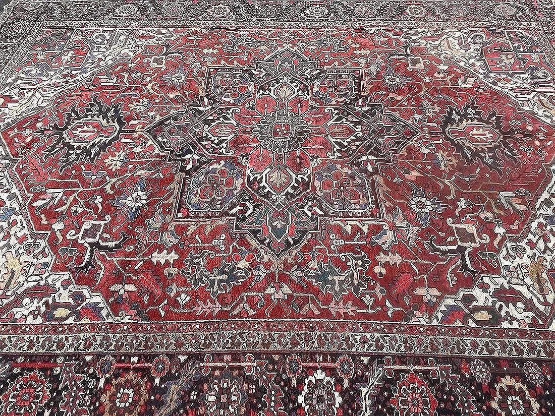 Antique large Persian Heriz hand woven rug 10 ft by 13 ft 6: Antique large Persian Heriz hand woven rug measuring 10 ft wide by 13 ft 6 inches long. A wool genuine Persian Heriz rug from the Northwest Persia. Unique geometric design on a rust field.