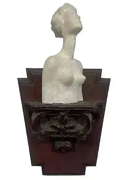 A unique Female Clay Bust on a sconce: Old Female clay bust on a sconce. A unique work by perhaps a follower of Alberto Giacometti. The sculpture measures 7 inches tall with wall hanging sconce pedestal measuring 8 inches tall.