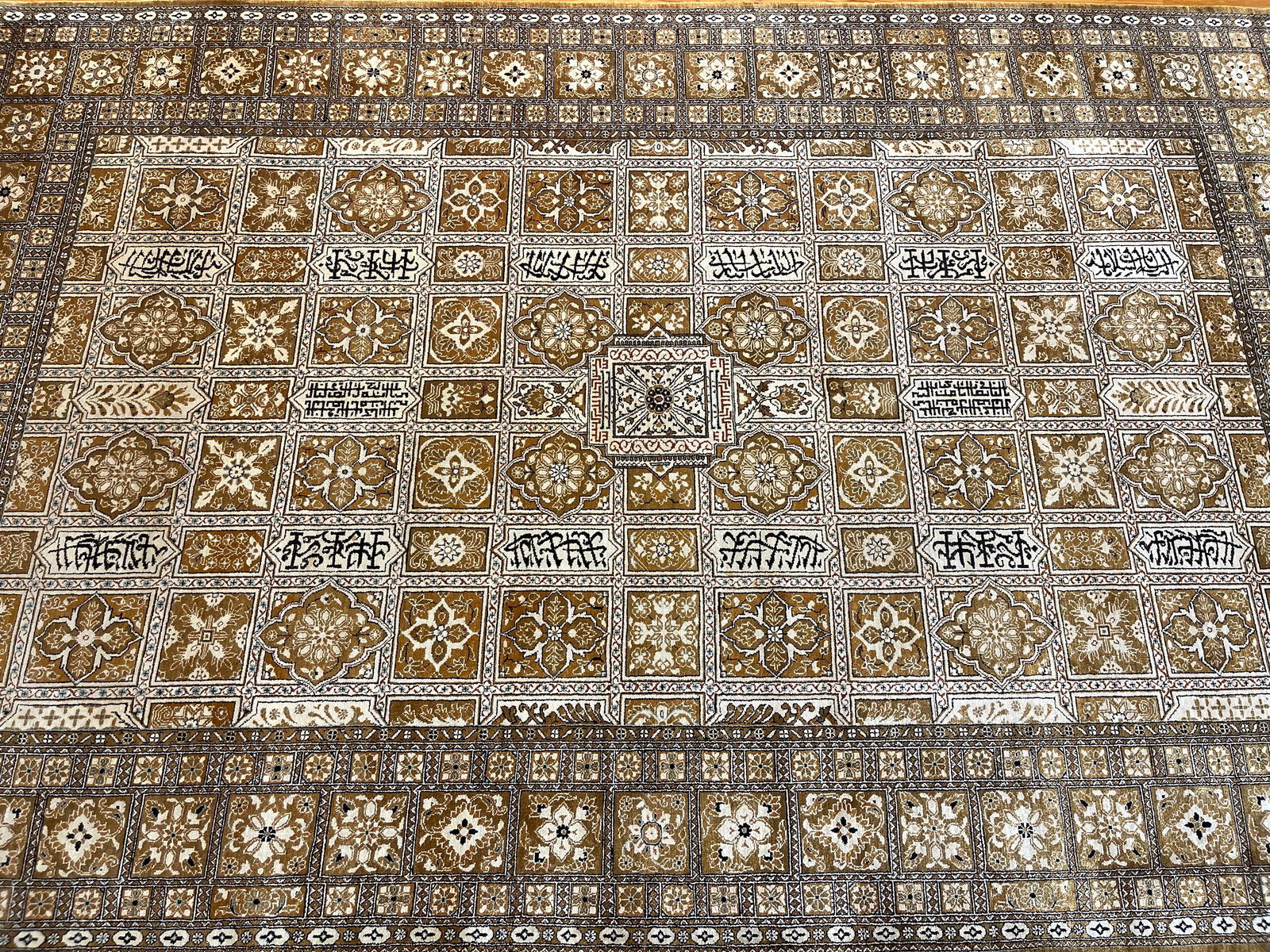 A Persian Silk Qum rug: A Persian pure Silk Qum rug measuring 4 feet 6 inches wide by 7 feet 1 inches long. A pure silk on silk genuine Persian Qum with a unique compartmental design and inscriptions. A finely handwoven