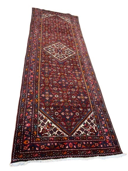 A Persian Hamadan tribal handwoven Runner: A Persian Hamadan tribal handwoven Runner measuring 3 feet 6 inches wide by 10 feet long. A wool on cotton tribal Persian Hamadan rug with a unique center medallion resting on an all over field.