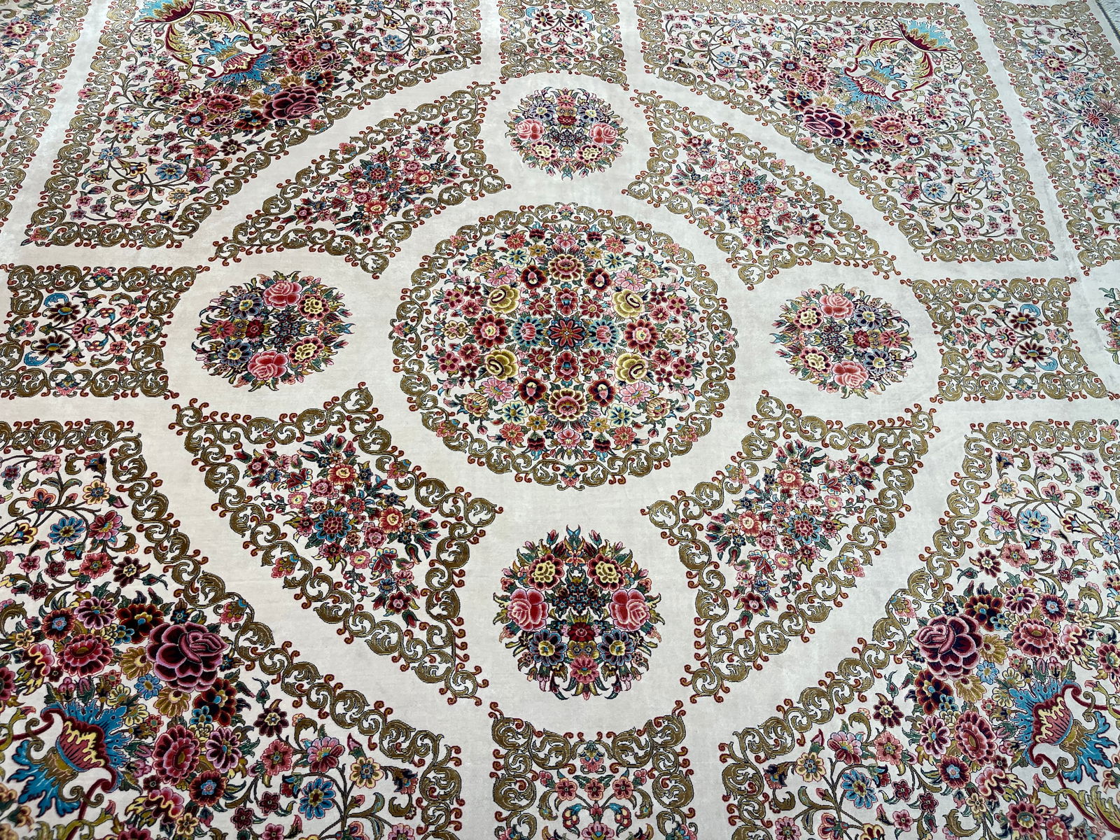 A Persian Silk Qum machine woven hand fringed rug: A Persian Silk Qum machine woven hand fringed rug measuring 6 feet 4 inches by 6 feet 6 inches long. A beautiful Brand New never used floral design rug. We Offer In house shipping to any USA