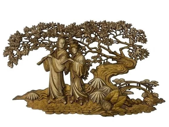 A large Asian decorative wall hanging sculpture art work: A large Asian decorative wall hanging sculpture art work. Measures 21 inches tall by 37 wide. Possibly a Japanese couple strolling into a garden with a bridge on the background. A unique reticulated c