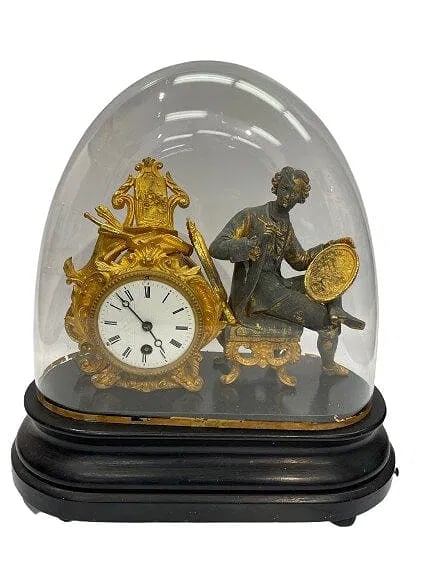 A 19th Century French figural mantel clock with a glass dome: A 19th Century French figural mantel clock with a glass dome and wooden oval base. A unique Gilted and patinated figure of an artist with a palette and a paint brush in hand. The clock has