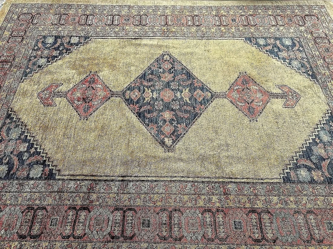 A Pakistan Bakshaish gold color handwoven room size wool rug: A Pakistan Bakshaish handwoven room size wool gold color rug measuring 8 feet 10 inches wide by 11 feet 6 inches long. A wool pile hand knotted tribal rug with an open field geometric design.