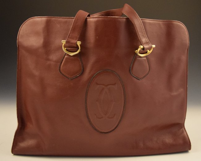 EMBOSSED LEATHER LES MUST DE CARTIER TOTE: Embossed Luxury Bordeaux Leather Les Must De Cartier Tote. Measures 16 x 12 inches and 18 inches with shoulder strap.