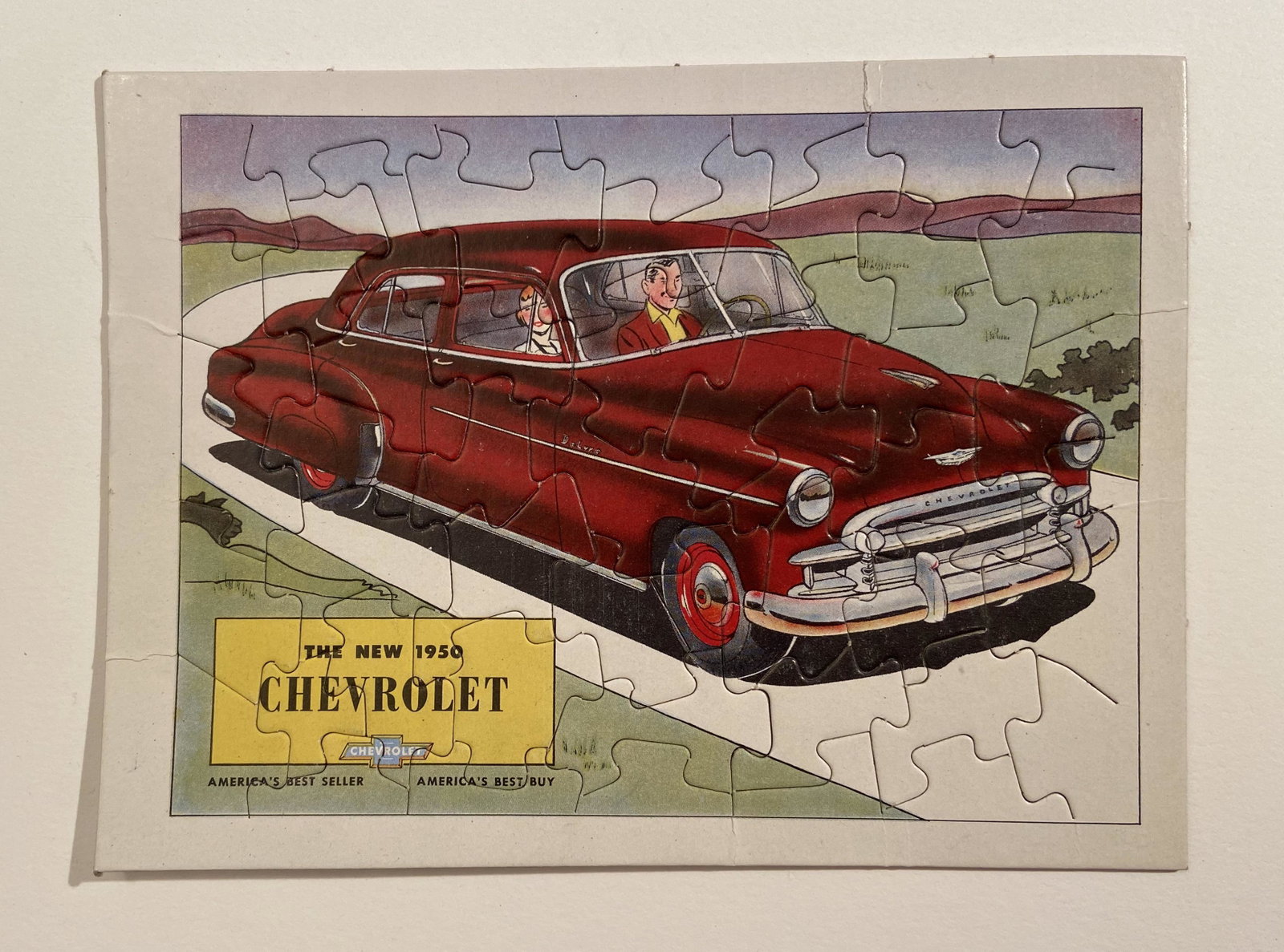The New 1950 Chevrolet Puzzle: The New 1950 Chevrolet Puzzle, a rare factory item produced in 1950 , with a envelope mailer. The back of the puzzle shows a black and white photo of the factory and the proving grounds with captions.