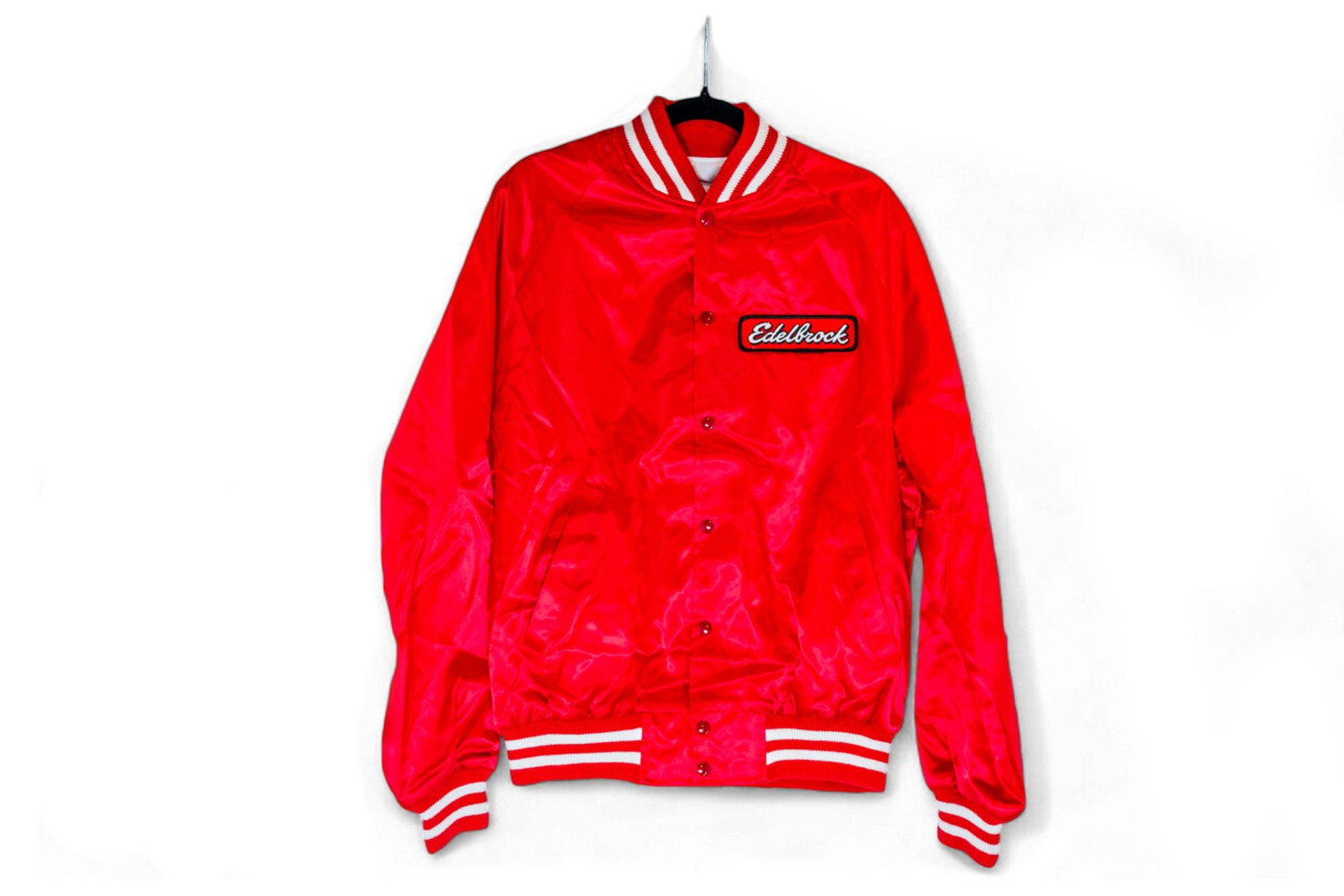 Edelbrock A red satin Edelbrock "Letterman-style" jacket from teh Edelbrock Museum Collection: Edelbrock A red satin Edelbrock "Letterman-style" jacket polyester coat with elastic waistband and cuffs, Edelbrock embroidered patch on left chest, men's size extra-large.