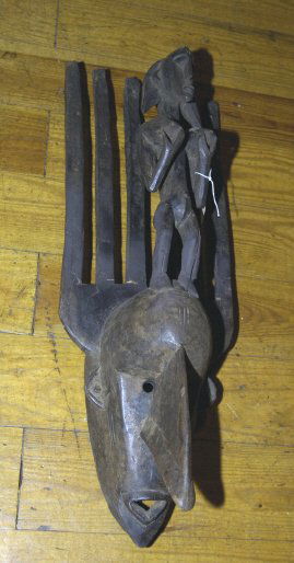 African mask with and extended nose and a woman: African mask with and extended nose and a woman standing on its head, one broken horn, 28" high