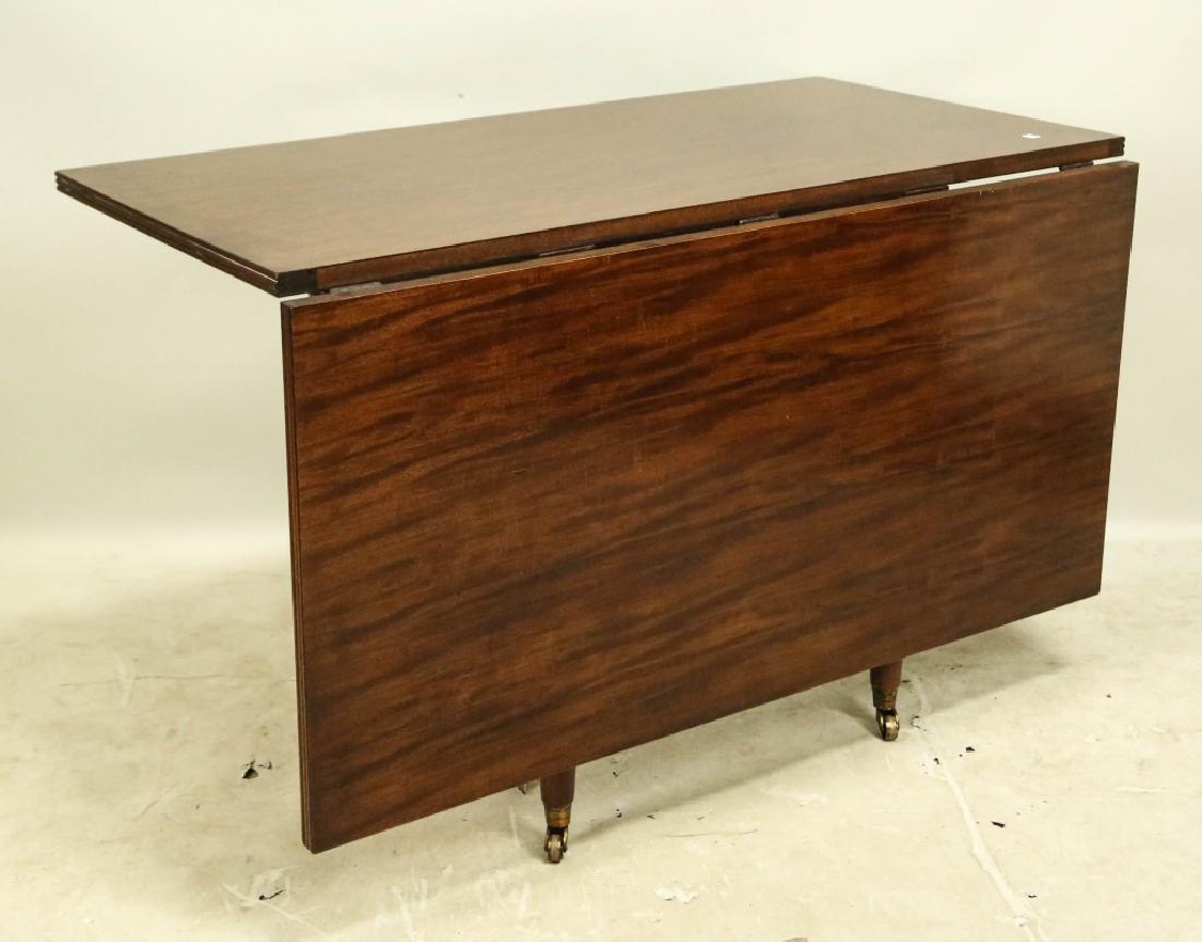 MAHOGANY DROP LEAF TABLE W/TURNED LEGS BRASS CASTE: MAHOGANY DROP LEAF TABLE WITH TURNED LEGS ON BRASS CASTERS. REEDED EDGE, TWO LEGS DRAW OUT TO DOUBLE THE SIZE. Height: 30 in. by Width: 24 & 48 in. by Depth: 48